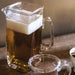  Glass pitcher with a handle, designed for easy pouring and serving of liquids.