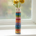 A decorative vase with blooming flowers rests on a window sill, illuminated by natural light.