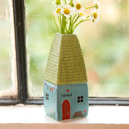 A small vase filled with fresh daisies, showcasing their white petals and yellow centers against a simple background.