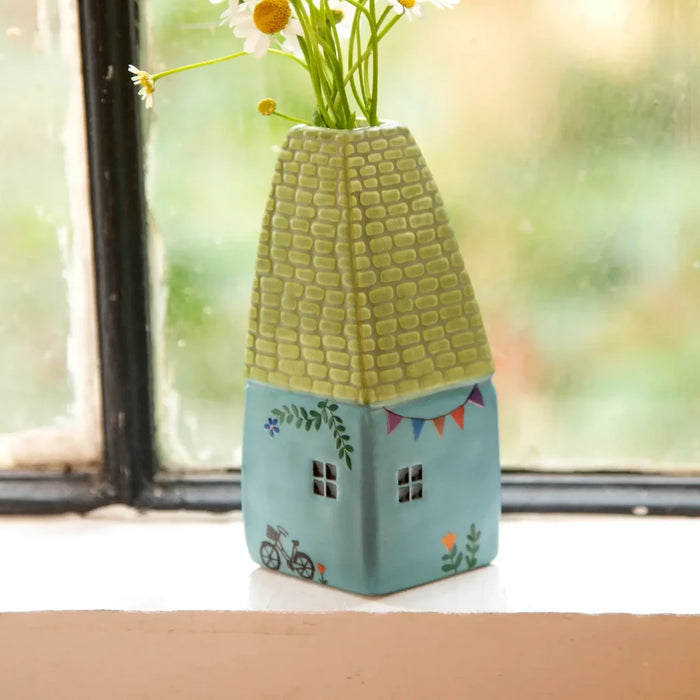 A delicate vase containing vibrant daisies, highlighting their cheerful white and yellow colors in a charming arrangement.