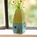 A small, elegant vase holding a bouquet of daisies, with their white petals and yellow centers creating a lively display.