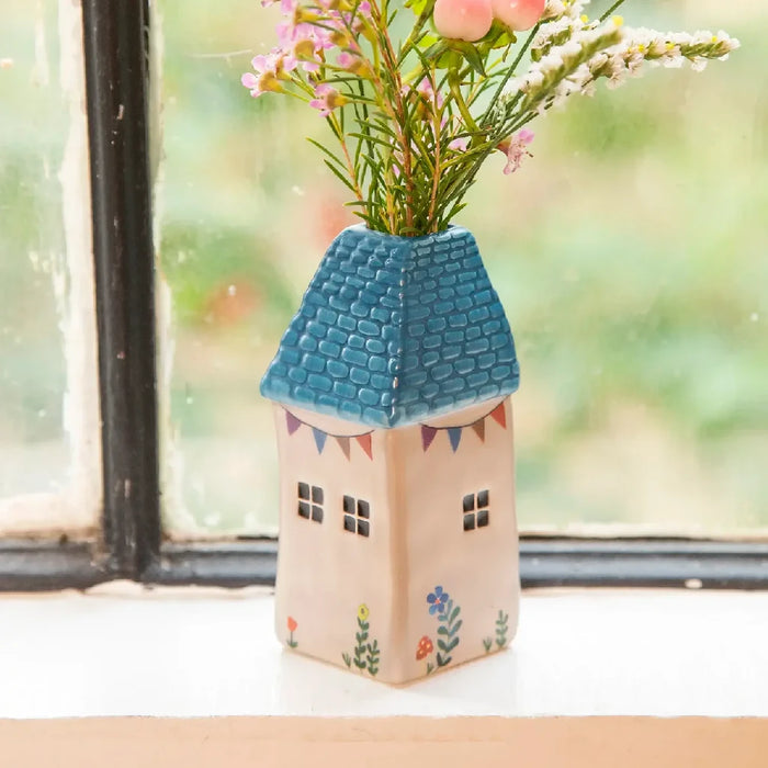 A lovely vase containing flowers sits on a window sill, inviting sunlight and warmth into the space.