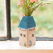 A lovely vase containing flowers sits on a window sill, inviting sunlight and warmth into the space.