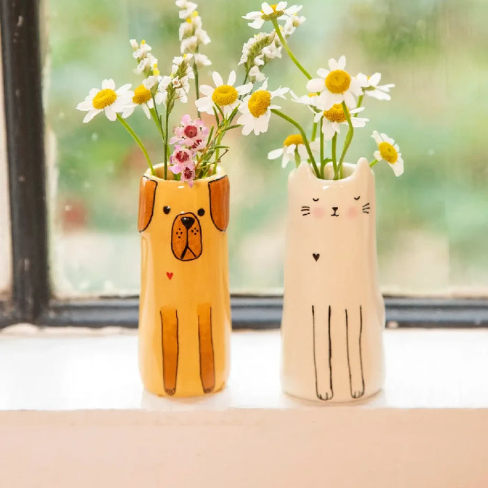 A whimsical yellow dog vase adorned with vibrant daisies, adding a playful touch to the decor.