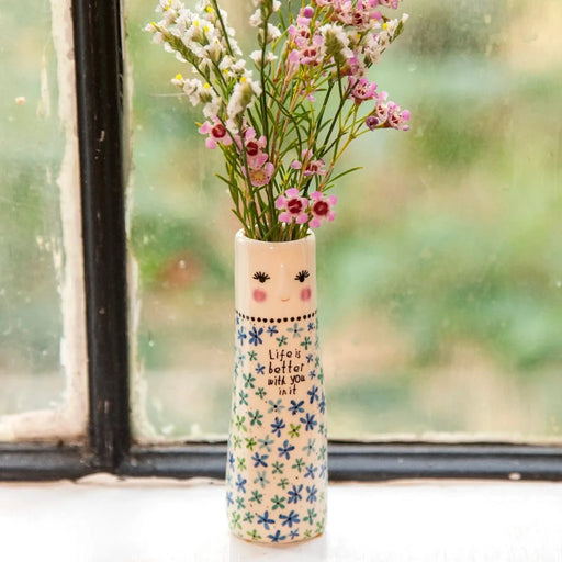 A vase filled with colorful flowers placed on a sunlit window sill, enhancing the room's natural light and beauty.
