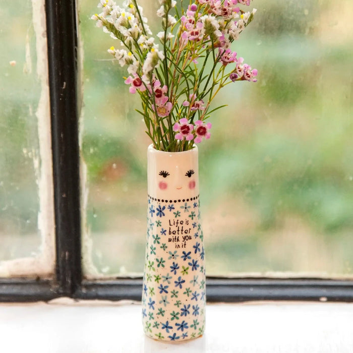 A vase filled with colorful flowers placed on a sunlit window sill, enhancing the room's natural light and beauty.
