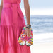Person holding colorful flip-flops with a beach background