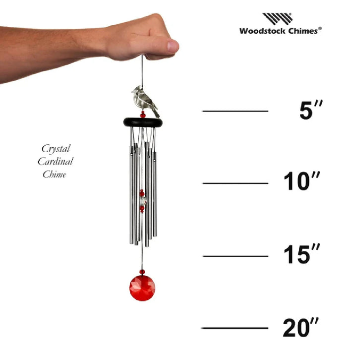 A red and white bird near a wind chime, capturing a moment of nature's beauty and tranquility.