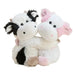 Two cute plush cow toys hugging, one with a black and white pattern and the other with pink accents, set against a plain light beige background.
