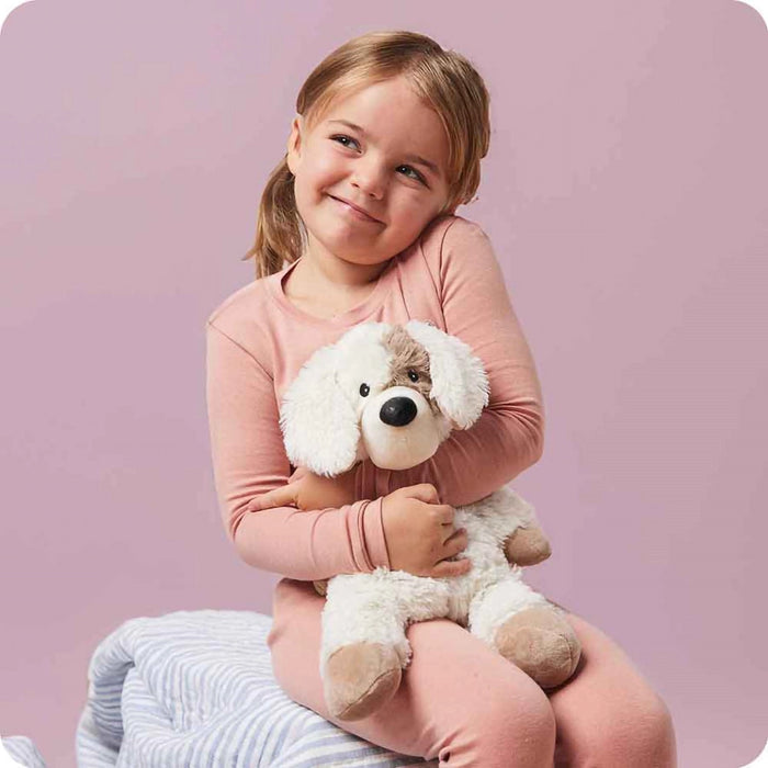 Child hugging a Warmies Puppy Plush microwavable stuffed animal for comfort and warmth