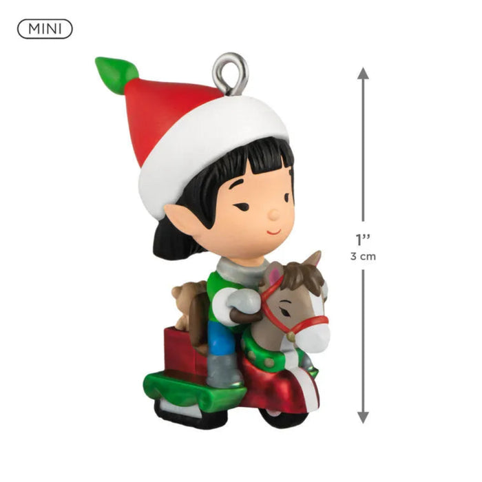 Christmas ornament of a child with a Santa hat riding a horse with measurements 