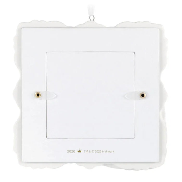White decorative photo frame ornament with scalloped edge on a white background