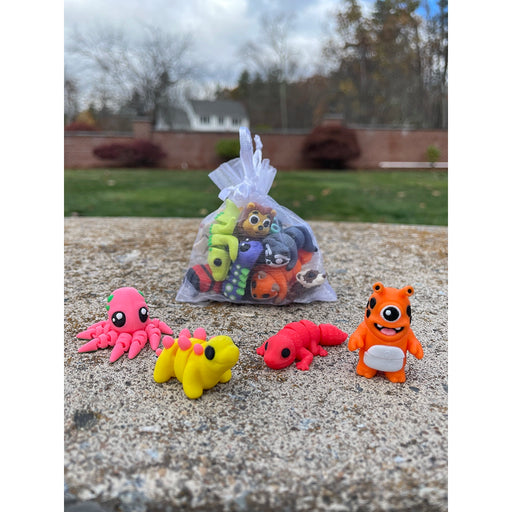 Small colorful animal wiggletz on a concrete surface with a garden background
