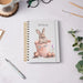 Wrendale Designs 'The Flower Pot' rabbit spiral bound notebook on desk with mug, pen, and greenery – countryside-inspired stationery gift.