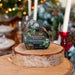 Frosted Fir & Holly soap packaging on a wooden stand with a festive background
