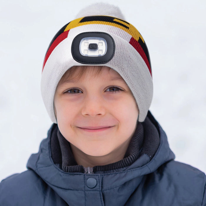 Child wearing a colorful beanie with a camera lens on a white background