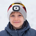 Child wearing a colorful beanie with a camera lens on a white background