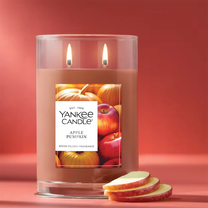 Yankee Candle Apple Pumpkin Large Tumbler burning beside apple slices – cozy autumn scent.