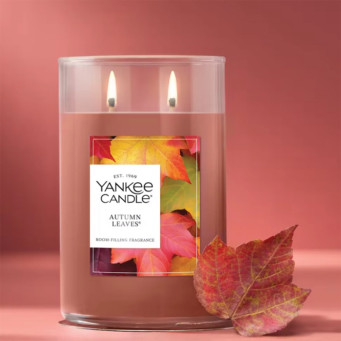 Unlit large Yankee Candle Autumn Leaves tumbler with two wicks and a silver lid, showing a label decorated with colorful fall leaves.