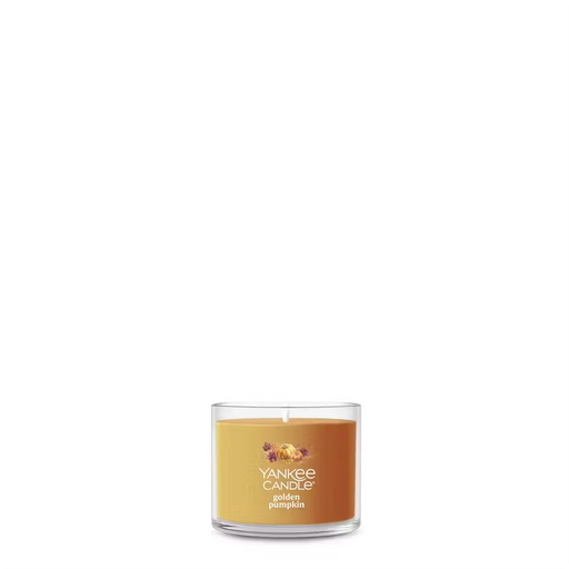 Unlit Yankee Candle Golden Pumpkin Mini in a clear glass jar with golden wax and pumpkin label.