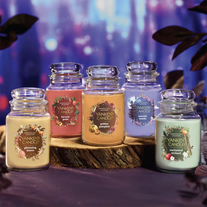 Fall Collection of Yankee Candle Original Jars on a wooden log with a blurred purple background