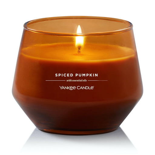 Yankee Candle Spiced Pumpkin lit in amber glass jar – cozy fall home décor.