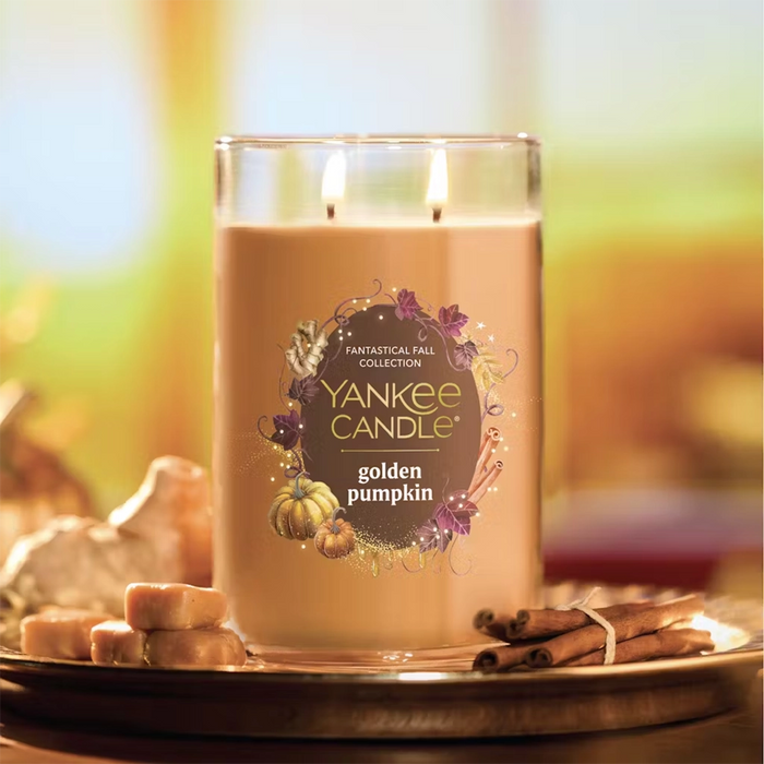 Yankee Candle golden pumpkin candle on a decorative plate with fall elements.