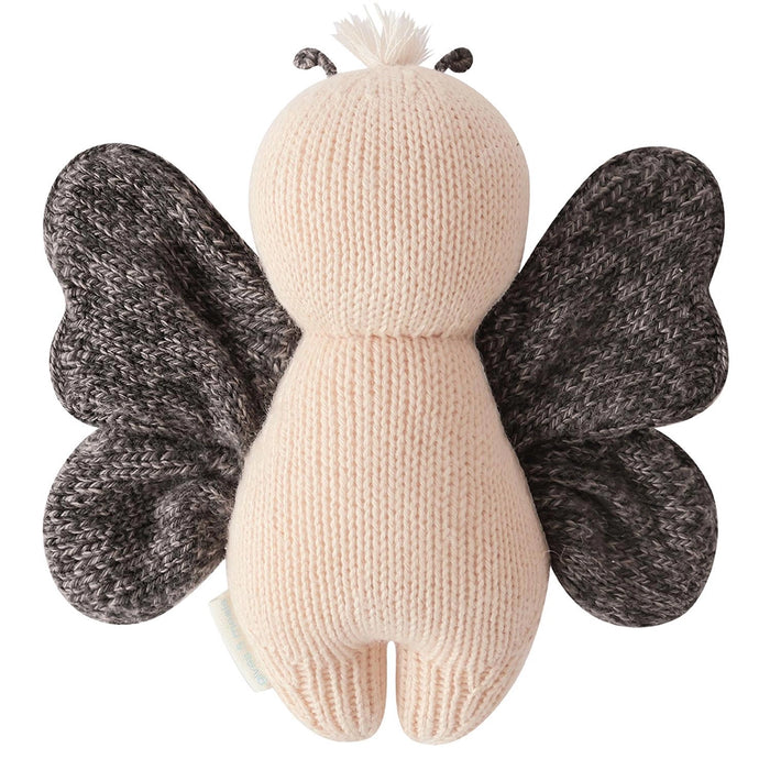 Back view of Cuddle + Kind Baby Butterfly in Peach – handmade knit doll with soft peach body and dark wings.