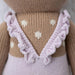Close-up of the back of the deer doll’s lavender romper, showing ruffled straps and white knitted spots.