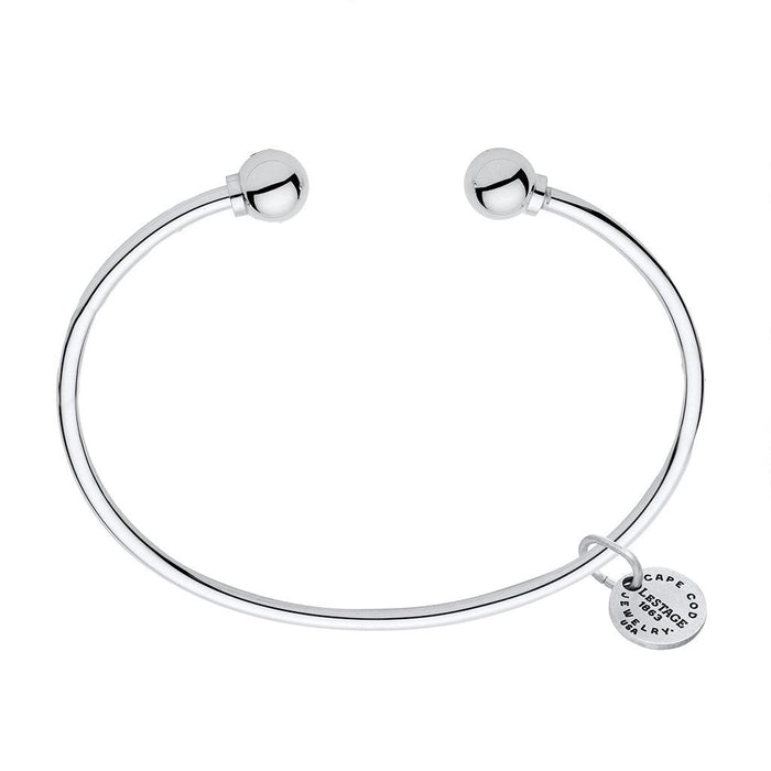 Silver bracelet with a round clasp and a tag on a white background