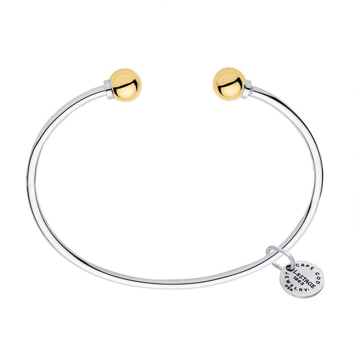 Silver bracelet with gold beads and a tag on a white background