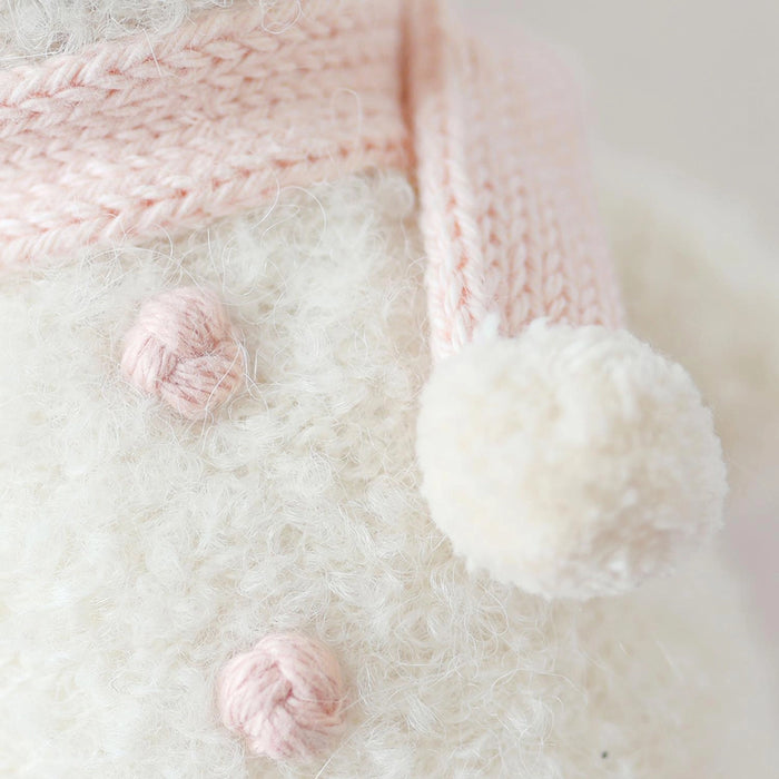 Close-up of Cuddle + Kind Baby Snowman in Blush Pink showing knit details, pink buttons, and soft scarf.