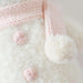 Close-up of Cuddle + Kind Baby Snowman in Blush Pink showing knit details, pink buttons, and soft scarf.