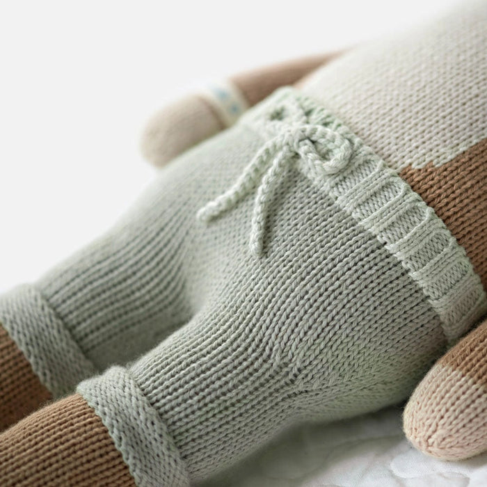 Close-up of Cuddle + Kind Elliott the Fawn’s mint green knit pants with drawstring detail, handmade plush toy.