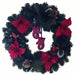 Christmas wreath with red poinsettias, pinecones, and mittens on a white background