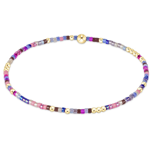 enewton design Hope Unwritten Bracelet in the Too Glam to Give a Jam multicolored beaded pattern with gold accents displayed in a circular shape on a white background.
