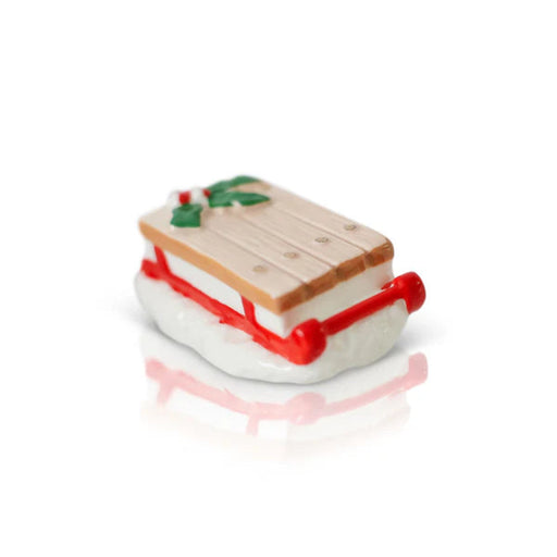 Nora Fleming Mini decorative Wooden Vintage Sled with a red runner and holly leaves on a white background