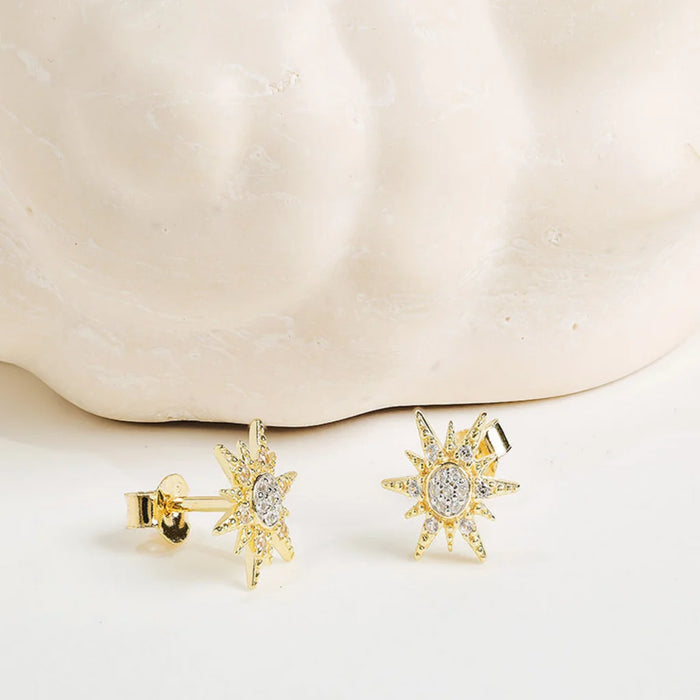 white Sapphire Sun Earrings on a light background