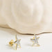 Gold starfish earrings on a light background