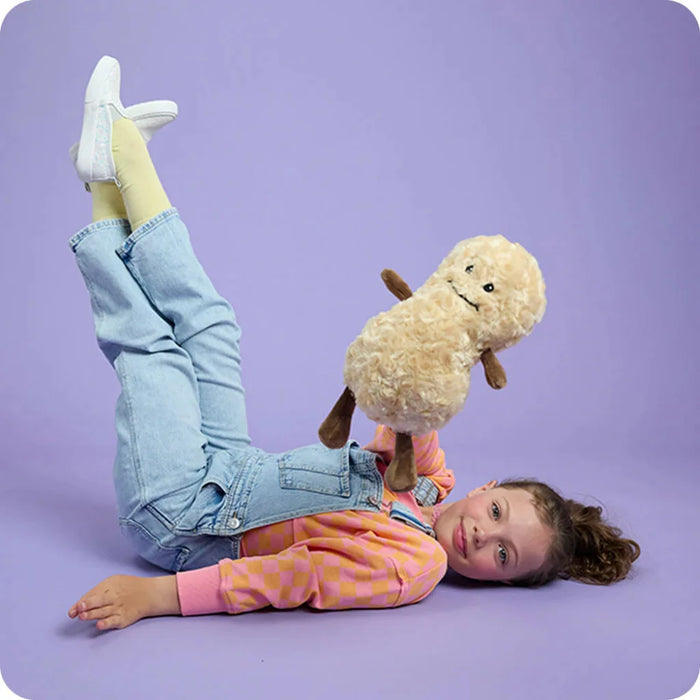 Child lying on a purple surface holding a plush toy with a purple background