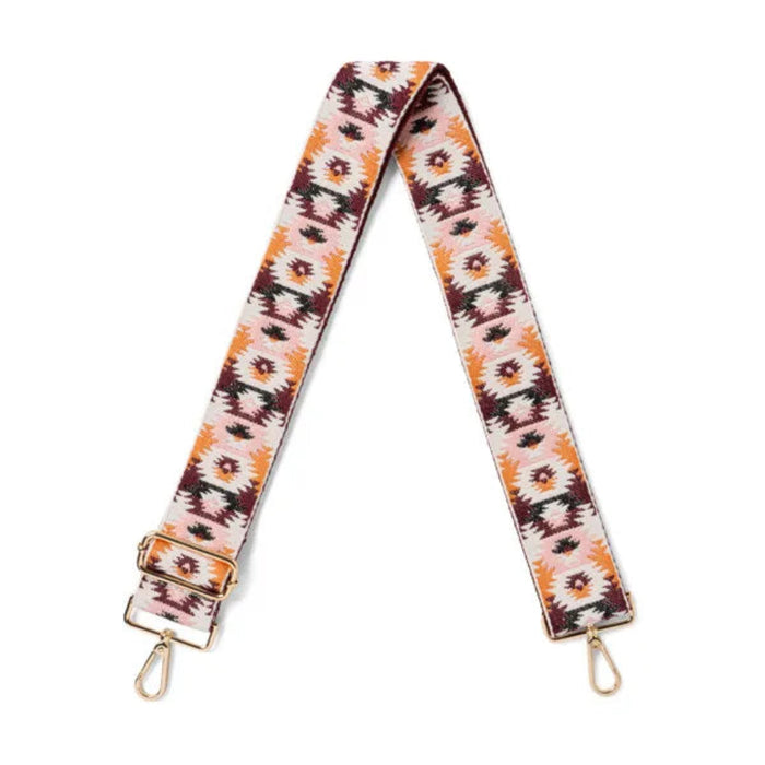 Patterned bag strap with gold hardware on a white background