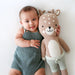 Baby cuddling with Cuddle + Kind Elliott the Fawn, large handmade knit deer doll with soft brown yarn and white spots.