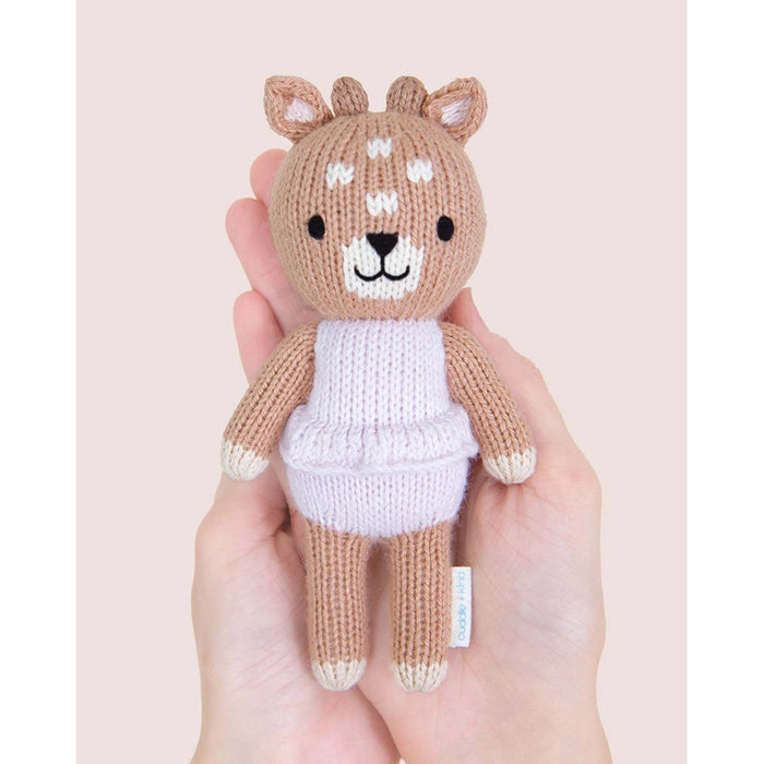 Tiny Violet the Fawn by Cuddle + Kind, small size hand-knit doll held in adult hands.