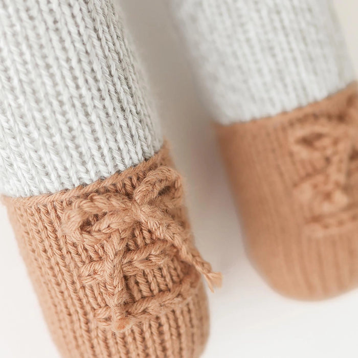 Hand-knit detail of Greyson the Penguin doll’s brown shoes with laces.