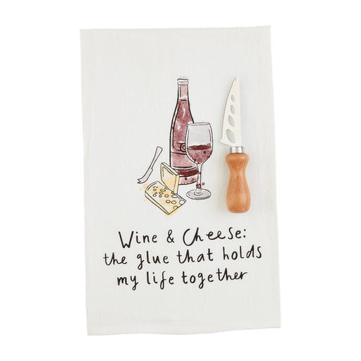 Mud Pie Wine and Cheese Towel Set featuring a cotton towel with wine and cheese illustration and quote “Wine & Cheese: the glue that holds my life together,” paired with a wooden-handled cheese knife.