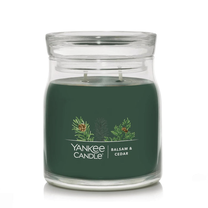 Yankee Candle Balsam & Cedar Signature Medium Jar with dark green wax and double wicks inside a clear glass jar.